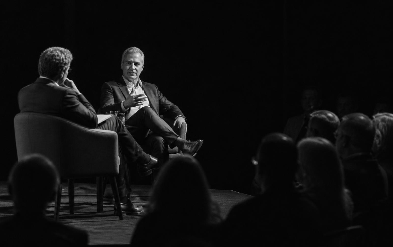 A fireside-format conversation on stage in front of a small audience